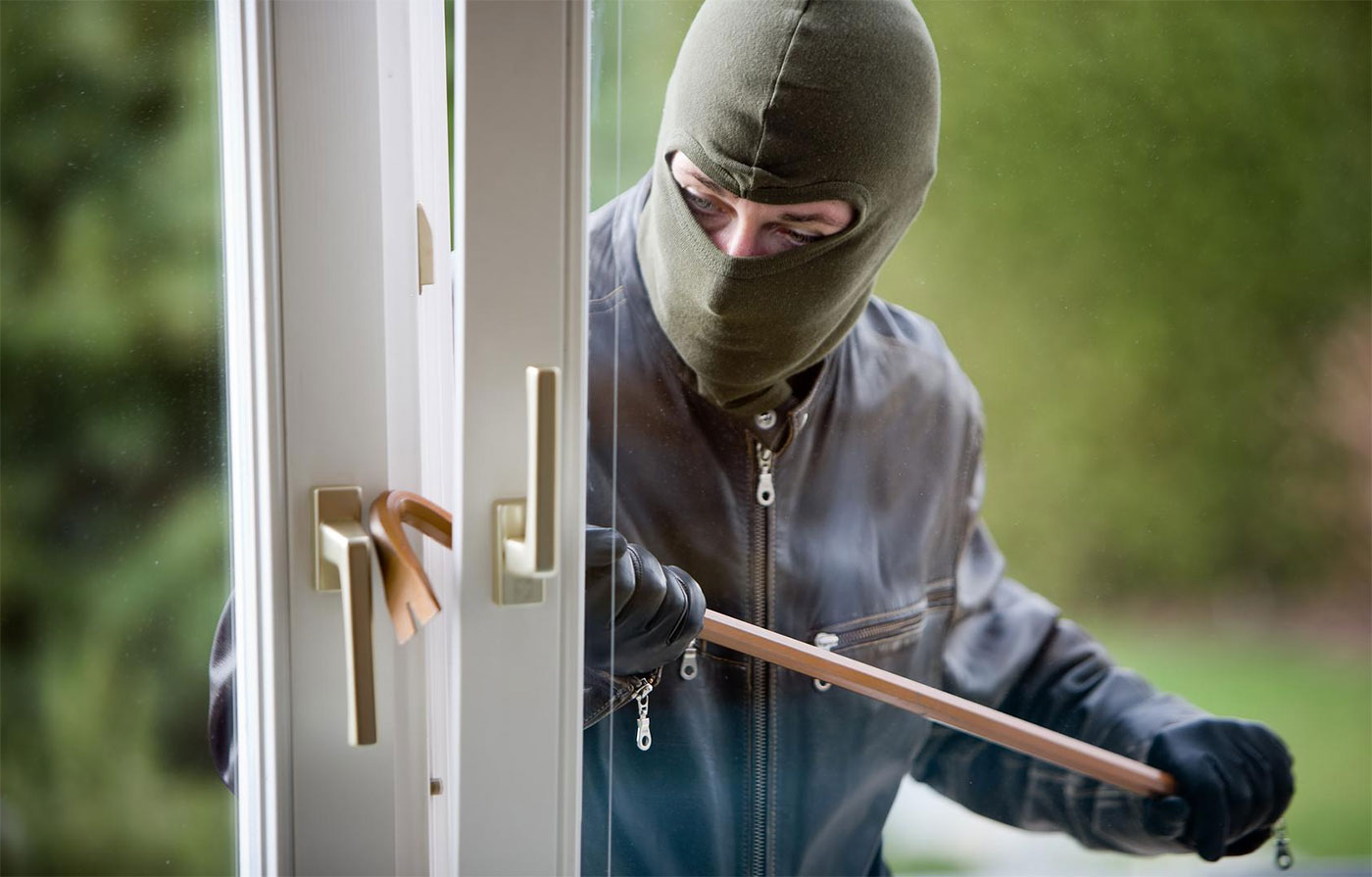 Burglar breaking in a monitored alarm house.